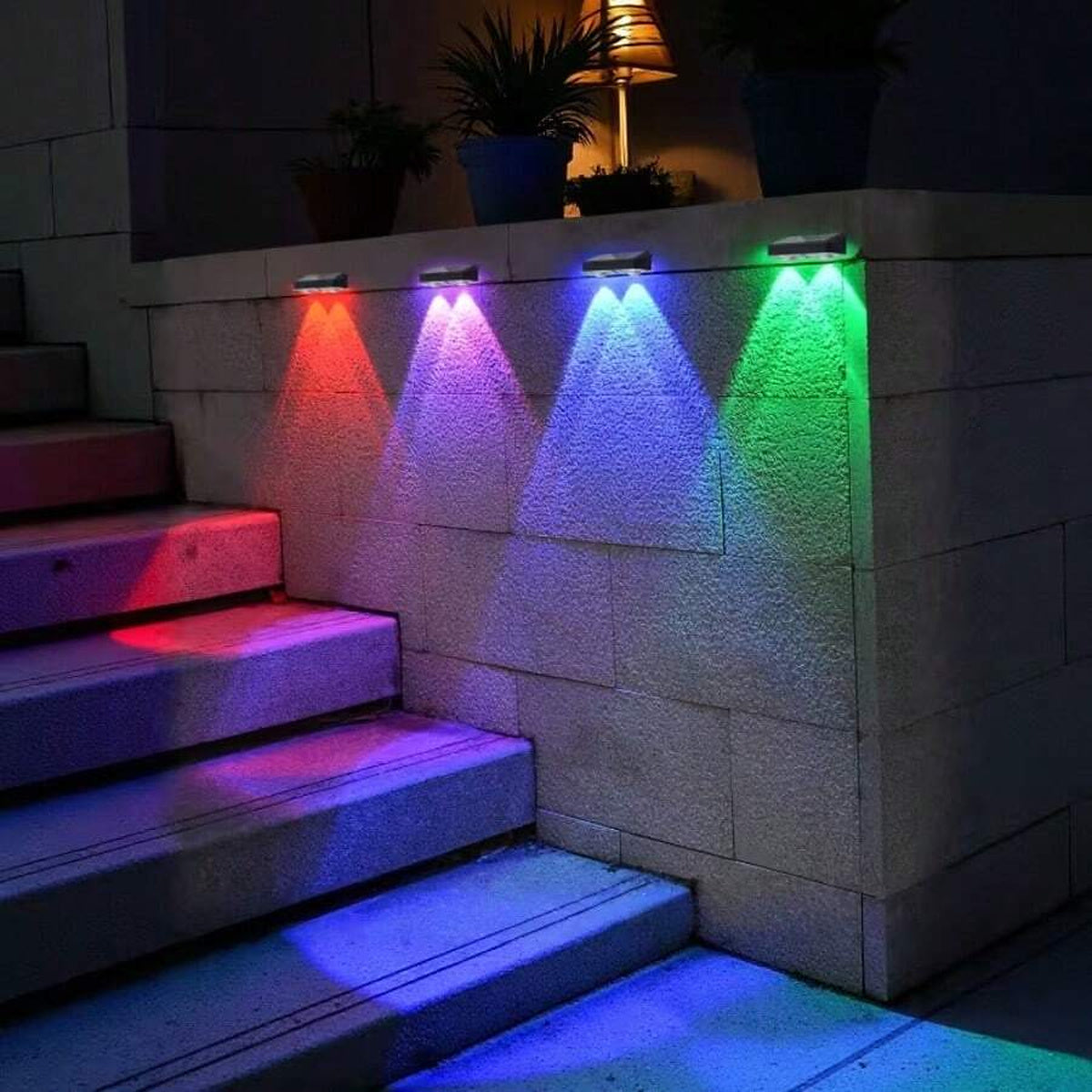 RGB solar fence lights illuminating an outdoor wall and steps