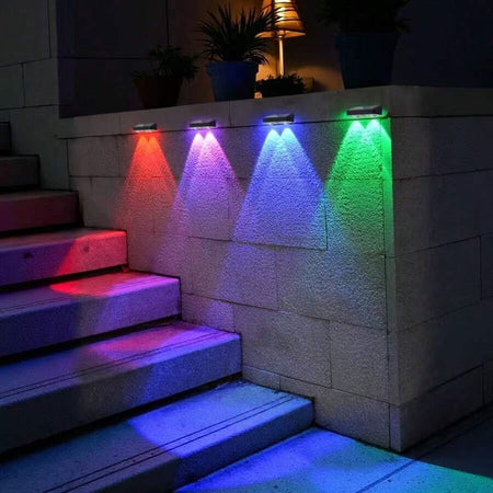 RGB solar fence lights illuminating an outdoor wall and steps